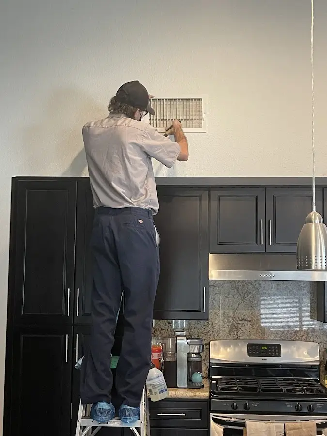 Technician inspecting an air vent during HVAC service in Indian Trail